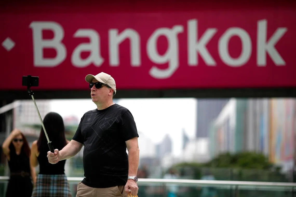 epa12397174 A foreign tourist takes a selfie with a sign reading 'Bangkok' in the background at a shopping district in Bangkok, Thailand, 22 September 2025. Thailand's economy has entered a slowdown phase, with the second half of 2025 expected to expand only around 1 percent, with the gross domestic product projected to grow between 1.8 and 2.2 percent in 2025, a significant revision down from earlier predictions, according to the Joint Standing Committee on Commerce, Industry, and Banking (JSCCIB).  EPA/RUNGROJ YONGRIT
