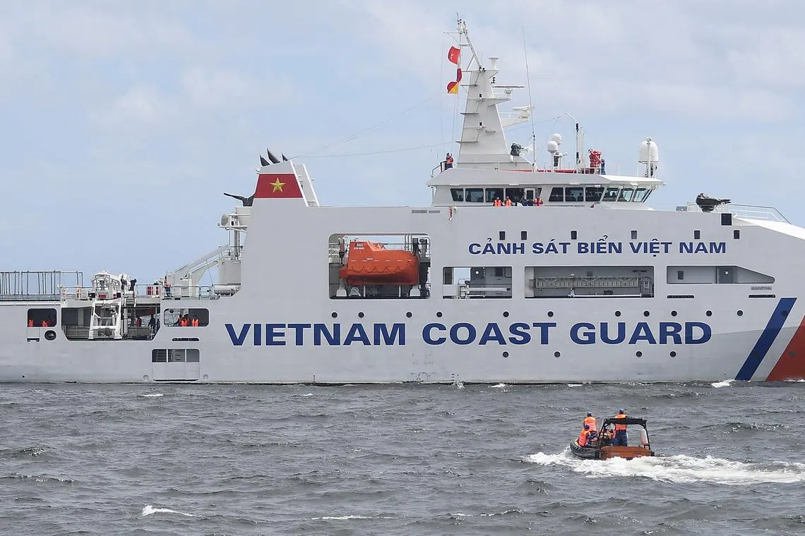 Vietnamese Coast Guard personnel sail their rigid hull inflatable boat past their ship during a joint maritime exercise with their Philippine counterparts off Bataan in the disputed South China Sea on August 9, 2024.  (Photo by Ted ALJIBE / AFP)