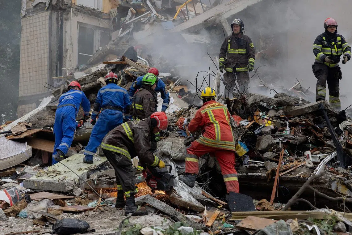 Rescuers clearing debris at the site of a residential building in Kyiv destroyed by a Russian strike on July 31.