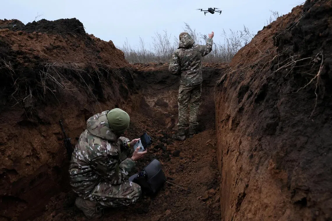 Two soldiers with the 58th Independent Motorized Infantry Brigade of the Ukrainian Army who wanted to be identified as "Ghost", 24, and "Soap", 30, release their drone for a test flight, as Russia's invasion of Ukraine continues, near Bakhmut, Ukraine, November 25, 2022. REUTERS/Leah Millis     TPX IMAGES OF THE DAY     