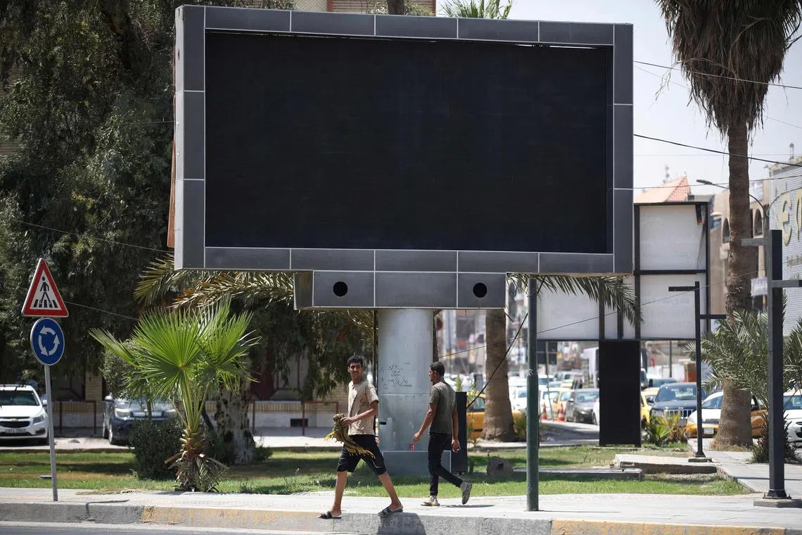Vehicles drive past a shut advertisement screen at the Uqba Bin Nafia square in Baghdad on August 20, 2023. Iraqi authorities ordered the shutdown of LED advertisement screens installed across Baghdad after a hacker managed to show a pornographic film on one, security forces said on August 20, announcing the arrest of a suspect. (Photo by Ahmad AL-RUBAYE / AFP)