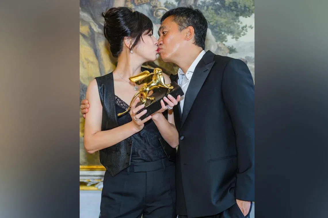 Carina Lau and Tony Leung Chiu-wai share a kiss to celebrate his Golden Lion Lifetime Achievement Award.