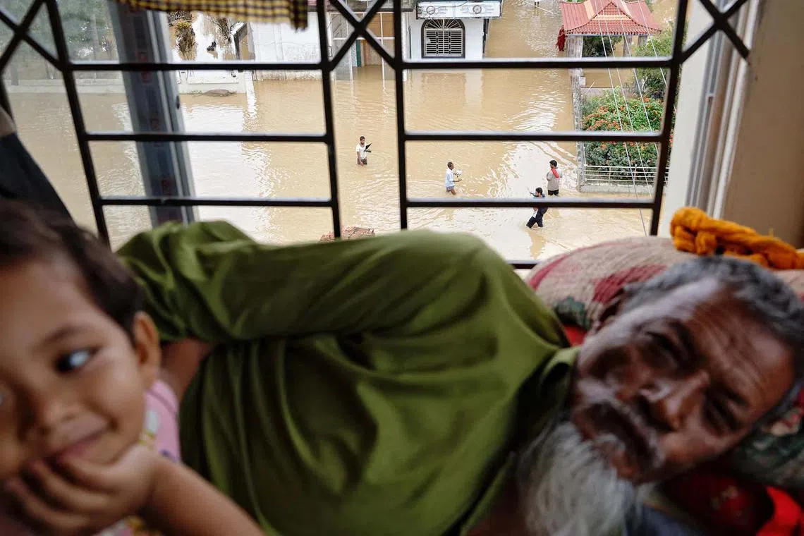 People wading through flood water are seen from a makeshift shelter amid severe flooding in the Fazilpur area of Feni, Bangladesh, Aug 26, 2024. 