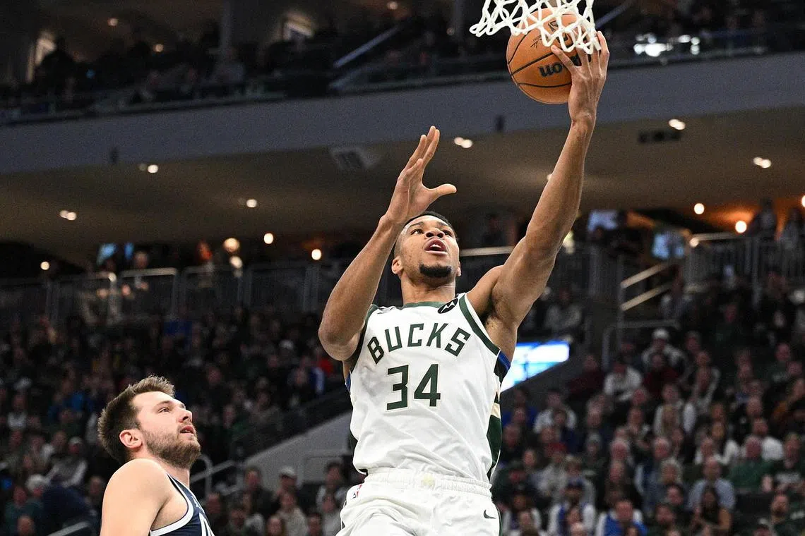Milwaukee Bucks forward Giannis Antetokounmpo driving to the basket against guard Luka Doncic in the first quarter at Fiserv Forum.