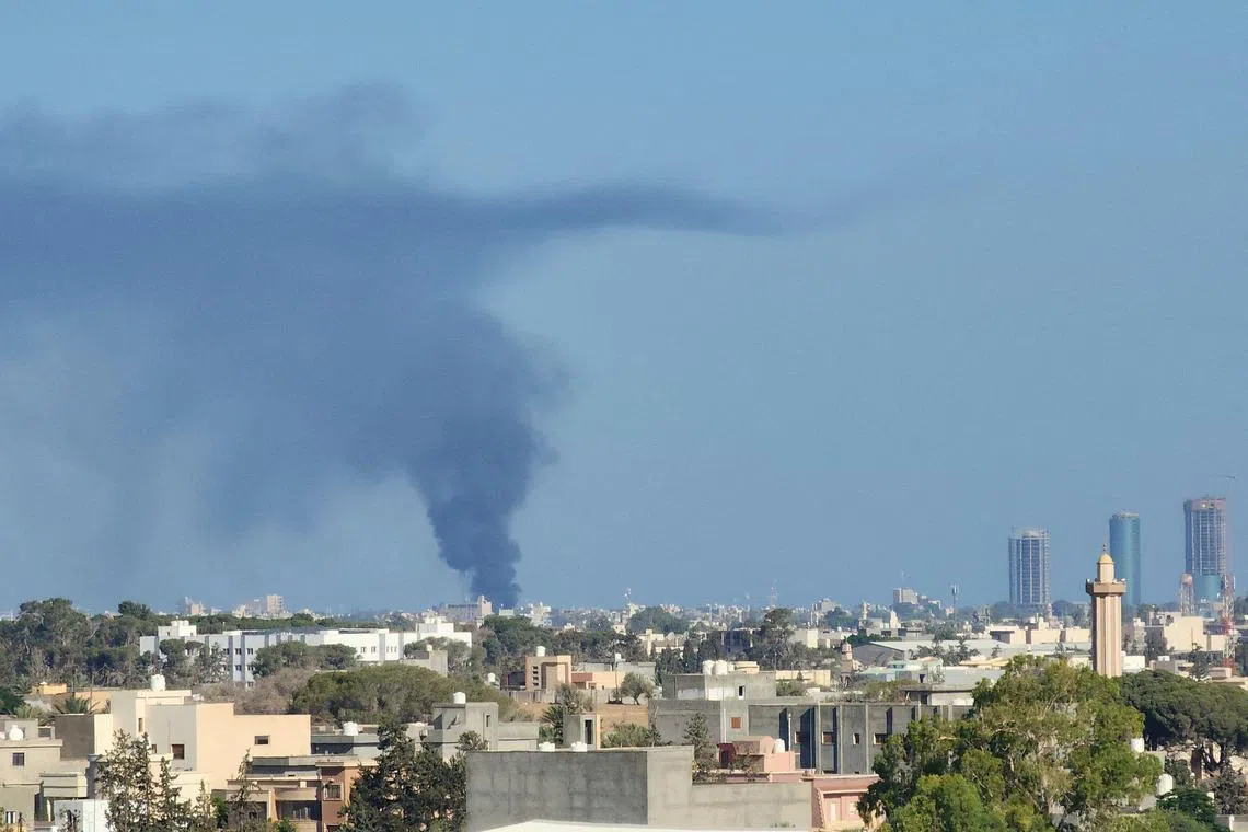 Smoke billows amid clashes between armed groups affiliated with Libya's Tripoli-based Government of National Unity (GNU) on August 15, 2023. (Photo by Mahmud TURKIA / AFP)