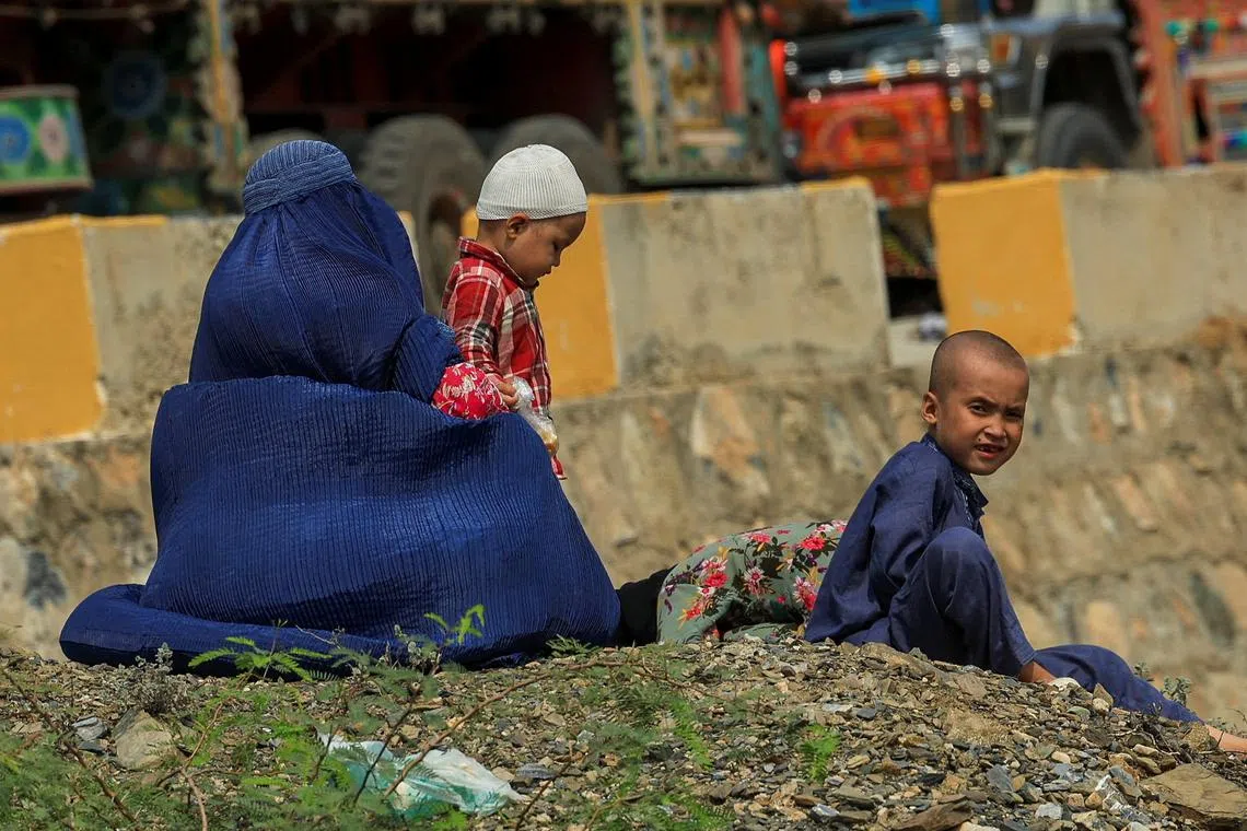FILE PHOTO: An Afghan family rests, as they head back to Afghanistan after Pakistan started to deport documented Afghan refugees, near Torkham border crossing between Pakistan and Afghanistan, September 1, 2025. REUTERS/Fayaz Aziz/File Photo