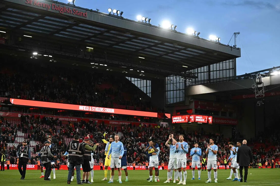 Manchester City players celebrating with fans on the pitch after thumping Liverpool 3-0 in the English Premier League at Anfield in on Oct 11.