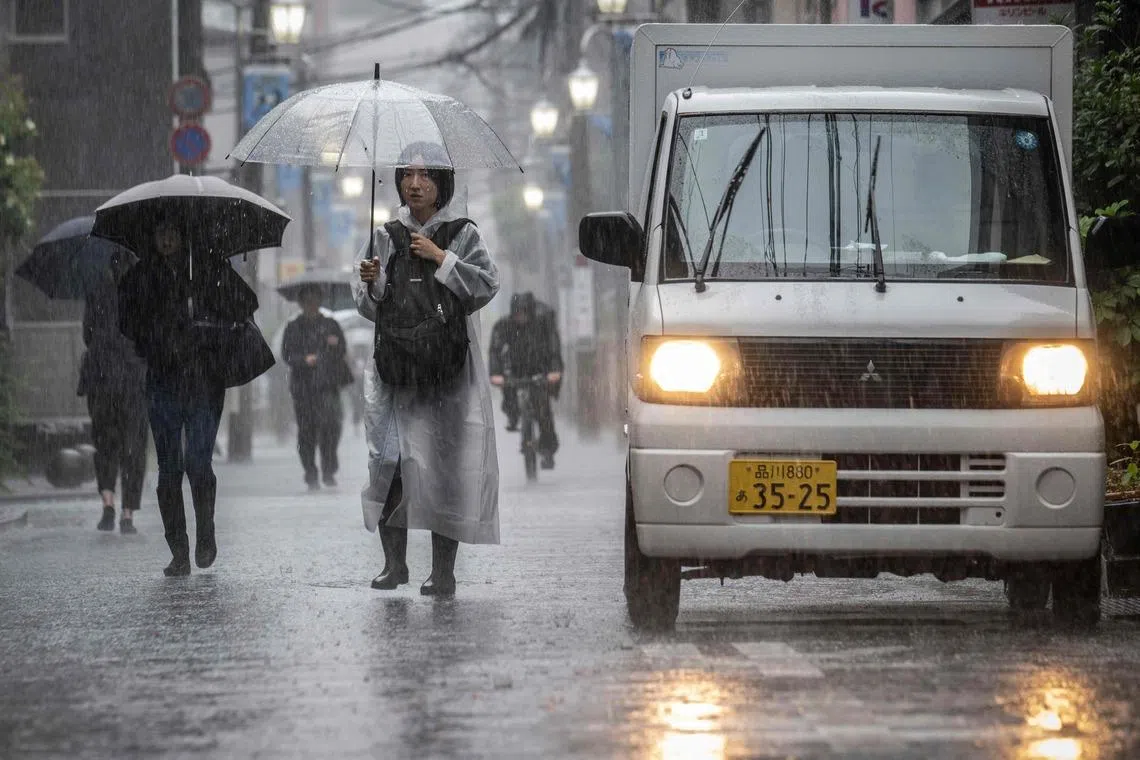 People commute in heavy rain brought by severe tropical storm Jangmi in Kawasaki, Kanagawa prefecture, Japan, on June 3.