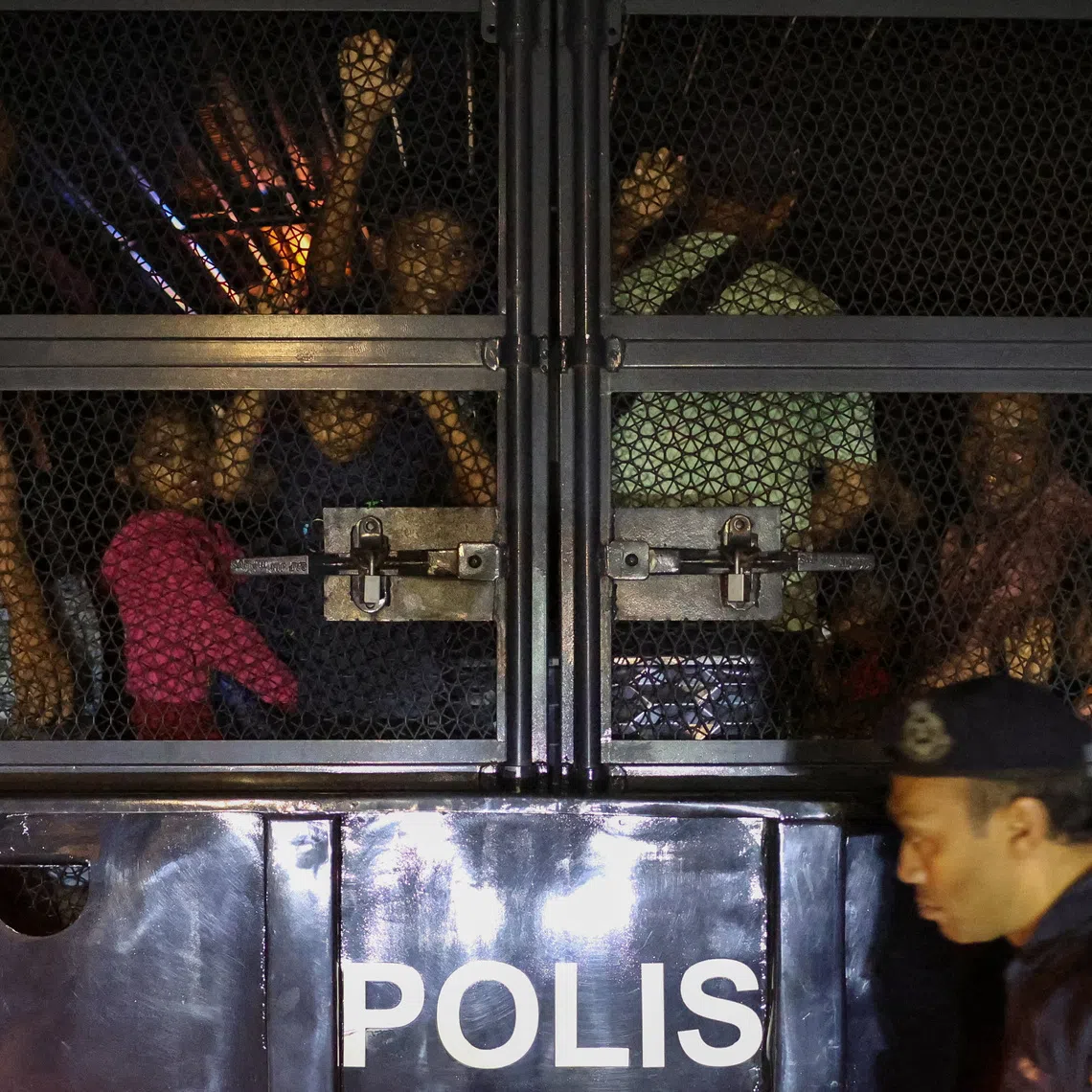 Rohingya refugees inside a truck as they are taken by police, in front of the office of the UN Refugee Agency in Kuala Lumpur on July 27.