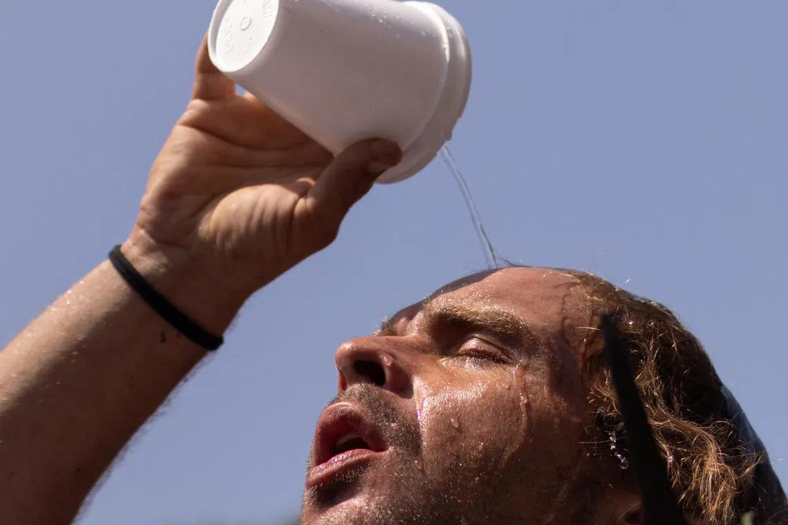 Nico pours water atop his head outside the Emergency Aid Coalition during a heat wave in Houston, Texas, U.S., August 25, 2023.  REUTERS/Adrees Latif
