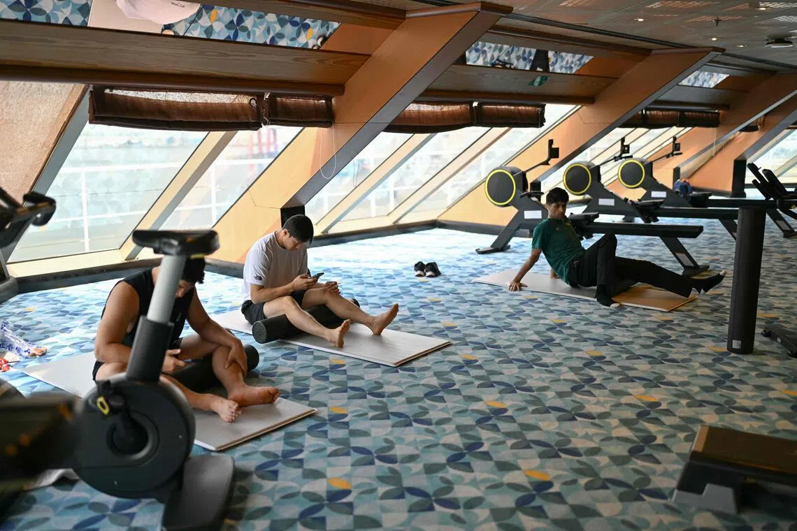 Athletes exercising in the gym on the Costa Serena cruise ship where Asian Games competitors and team members are staying.