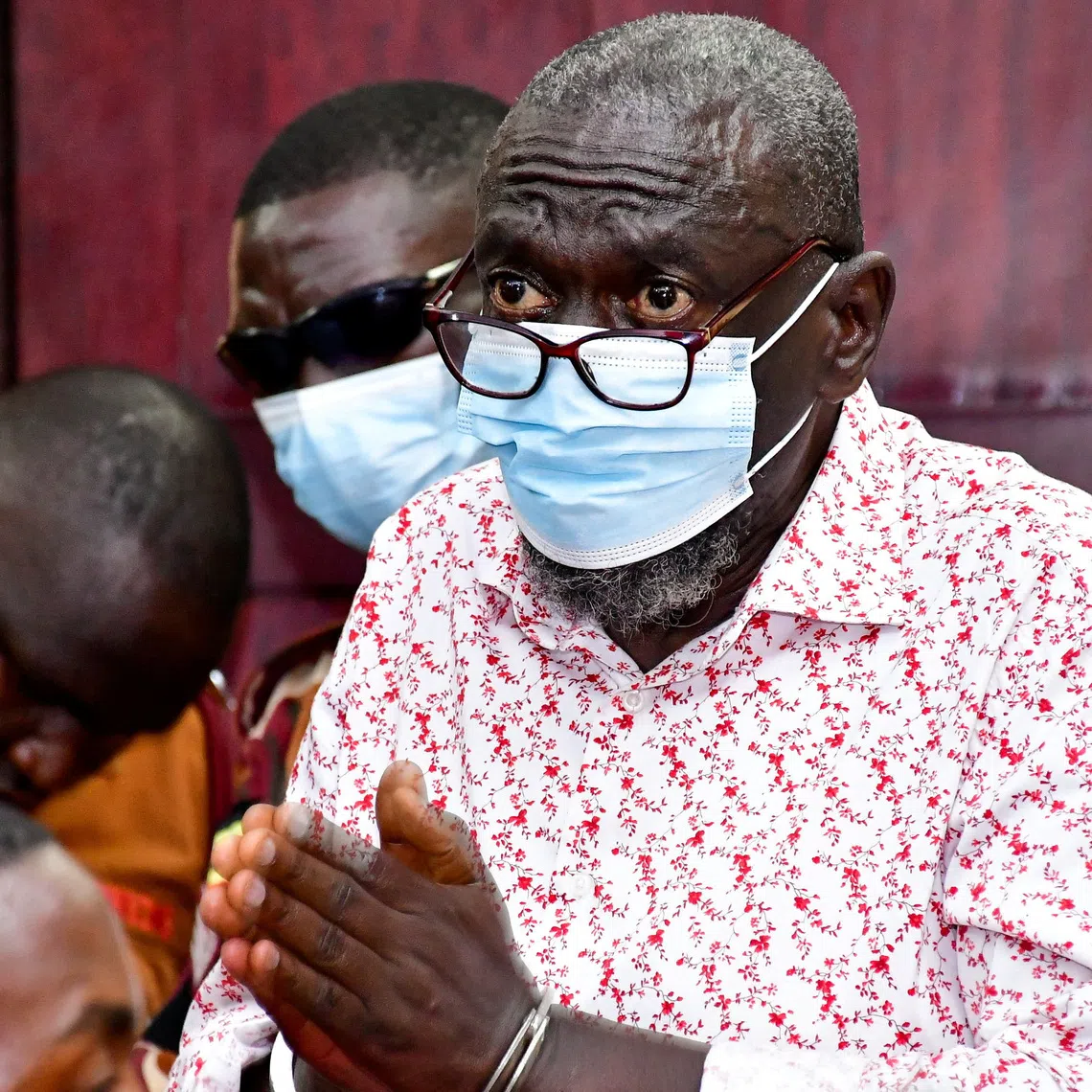 Detained Ugandan opposition figure Kizza Besigye gestures before he collapsed while attending a court session where he is on trial for treason, at the High court in Kampala, Uganda, July 29, 2026. REUTERS/Abubaker Lubowa