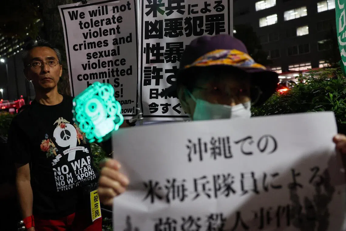 Demonstrators hold placards during a protest outside Foreign Ministry building on Oct 8 following the killing of a Japanese woman in Okinawa, for which a US Marine is a suspect.