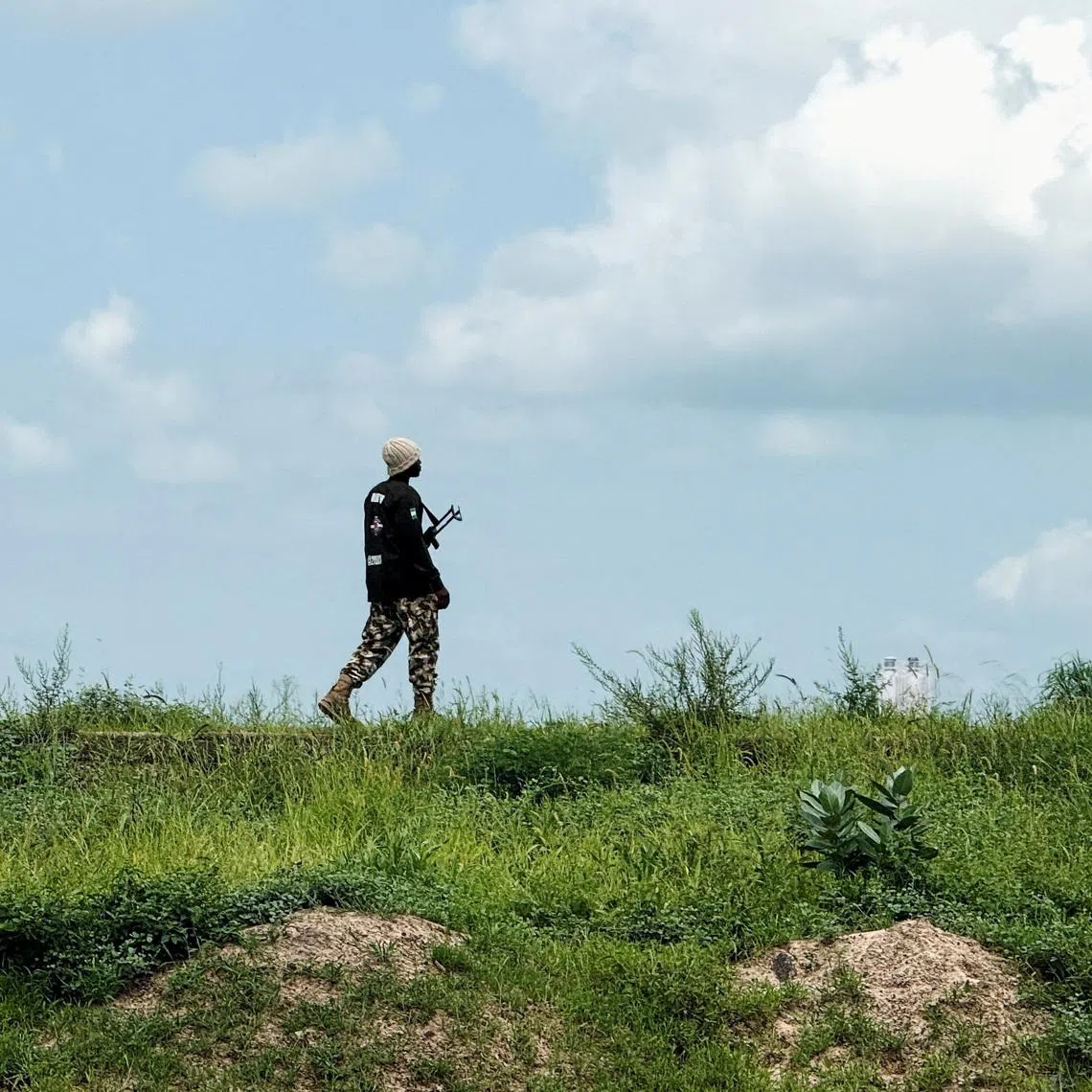 FILE PHOTO: A Nigerian Army personnel stands guard as farmers return from their fields after receiving security clearance in Dikwa town, Borno State, Nigeria, August 27, 2025. REUTERS/Sodiq Adelakun/File Photo