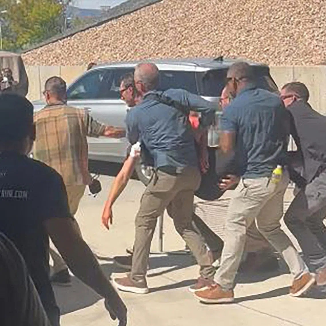 Security personnel (right) carrying Mr Charlie Kirk after he was shot during a public event at Utah Valley University on Sept 10.