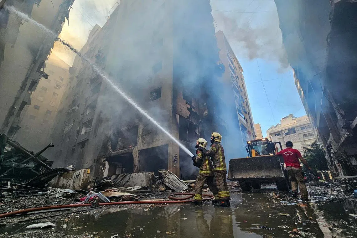 TOPSHOT - Firefighters battle the flames of a buildings hit an Israeli airstrike that targeted the neighbourhood of Haret Hreik in Beirut's southern suburbs on November 21, 2024, amid the ongoing war between Israel and Hezbollah. (Photo by AFP)