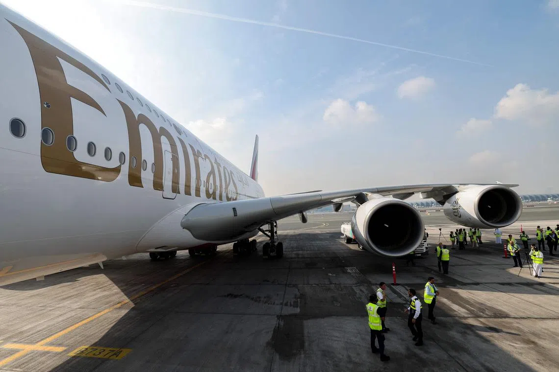 Ground crew prepare an Emirates Airbus A 380-800 aircraft, powering one of its engines with a hundred per cent Sustainable Aviation Fuel (SAF), for a demonstration flight at the Dubai International Airport in Dubai, on November 22, 2023. (Photo by Giuseppe CACACE / AFP)