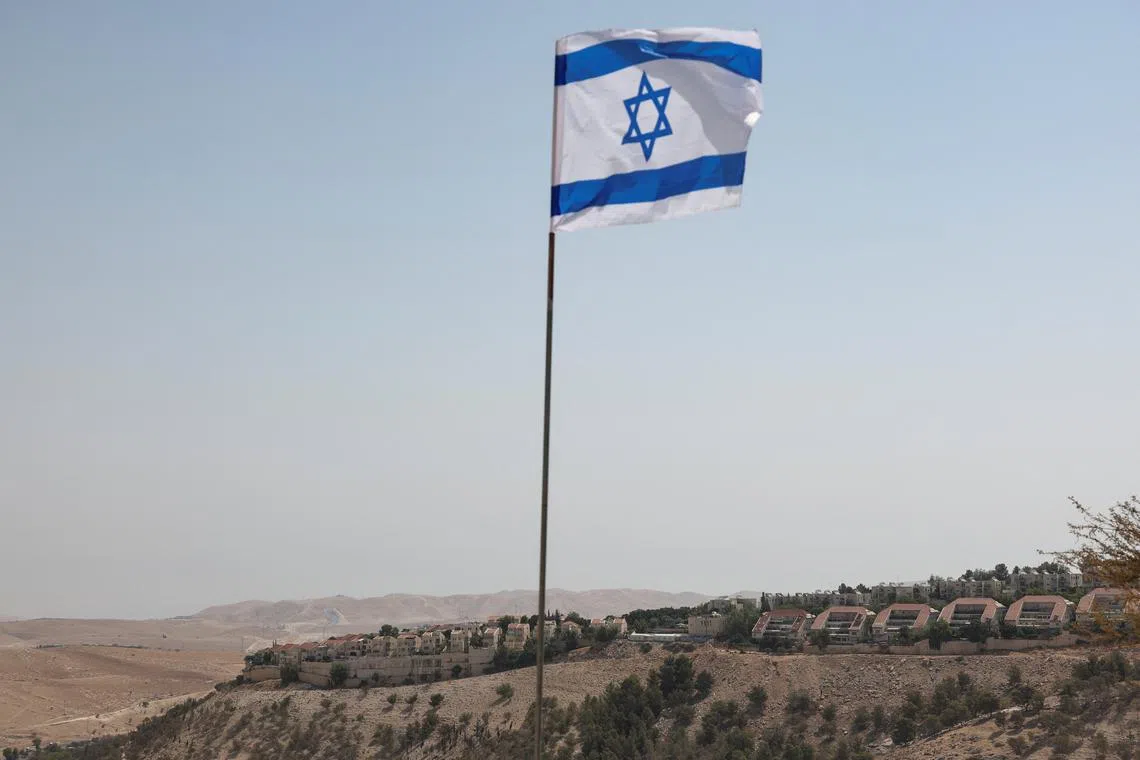 FILE PHOTO: An Israeli flag flutters, as part of the Israeli settlement of Maale Adumim is visible in the background, in the Israeli-occupied West Bank, August 14, 2025. REUTERS/Ronen Zvulun/File Photo