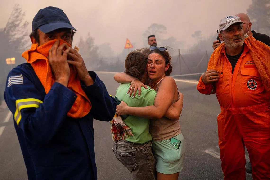 Women embracing after being rescued during a wildfire in Varnavas, north of Athens, on Aug 11, 2024. 