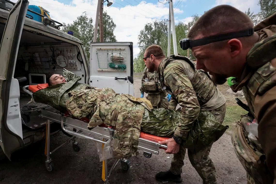 Military paramedics treat a wounded Ukrainian service member, amid Russia's attack on Ukraine, near the town of Vovchansk in Kharkiv region, Ukraine May 12, 2024. REUTERS/Vyacheslav Madiyevskyy