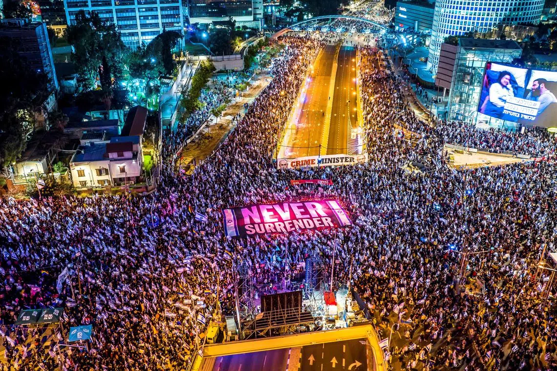 People protest in Tel Aviv, on March 18, 2023, for an 11th straight week, against the government's contentious judicial overhaul.