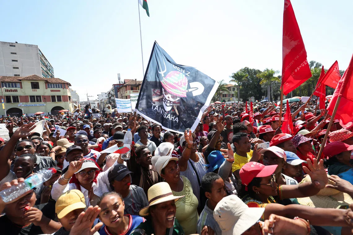 A person joins others holding a flag featuring a Malagasy version of the logo from the popular Japanese manga One Piece, a symbol adopted by Gen Z protest movements worldwide, during a gathering along Independence Avenue, following the swearing-in of Colonel Michael Randrianirina as president the previous day, after youth-led protests ousted his predecessor, in Antananarivo, Madagascar, October 18, 2025. REUTERS/Siphiwe Sibeko