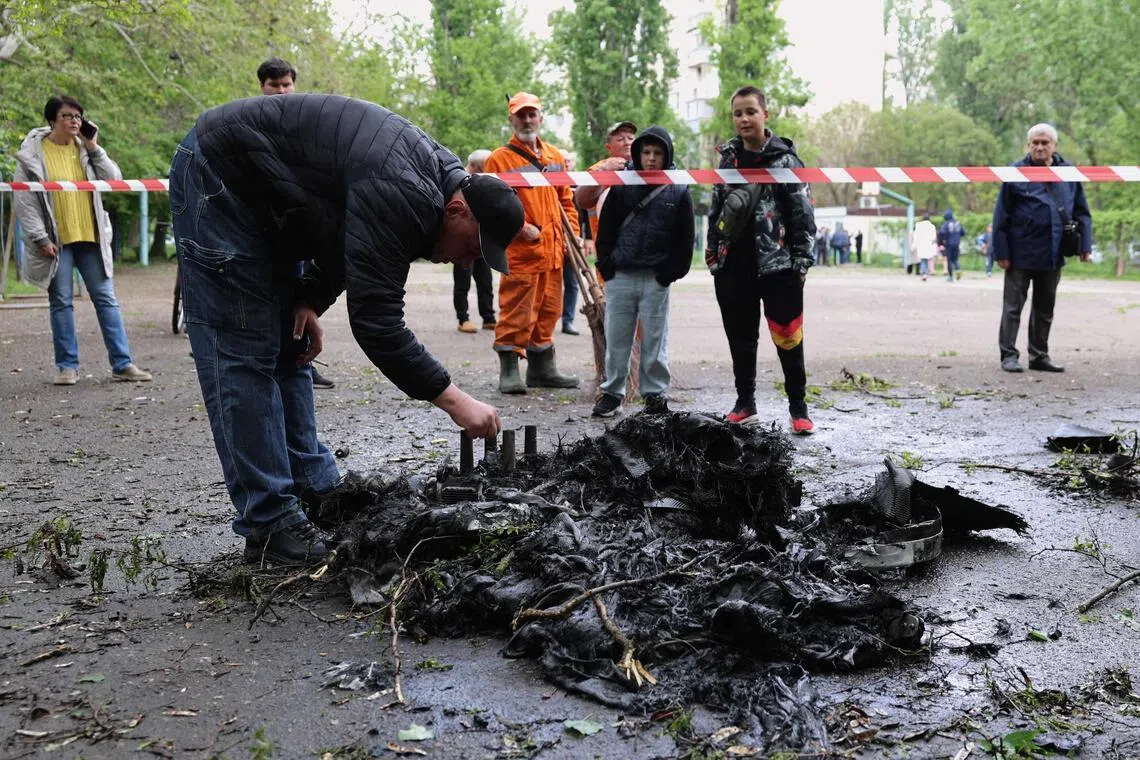 A man inspecting the remnants of a drone in the courtyard of a residential building in Odesa on May 13, following a Russian attack.