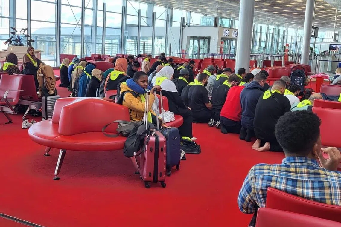 Several dozen travellers in the departures’ hall of Charles de Gaulle airport in Paris praying together ahead of a flight to Jordan.