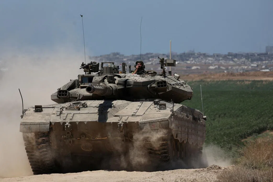 FILE PHOTO: An Israeli tank manoeuvres near the Israel-Gaza border, amid the ongoing conflict between Israel and the Palestinian Islamist group Hamas, in Israel, May 16, 2024. REUTERS/Shannon Stapleton/File Photo