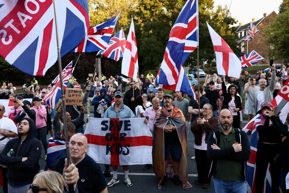 FILE PHOTO: People protest outside Epping Forest District Council, after the British government won a court ruling resulting in asylum seekers not being evicted from The Bell Hotel in Epping, Britain, August 31, 2025. REUTERS/Jack Taylor/File Photo