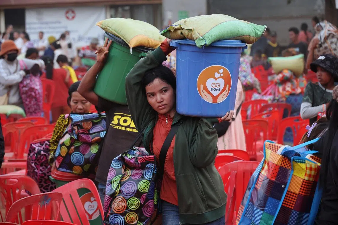 People carrying supplies at Batthkav refugee camp in Cambodia on Dec 12, amid ongoing border clashes between Thailand and Cambodia.