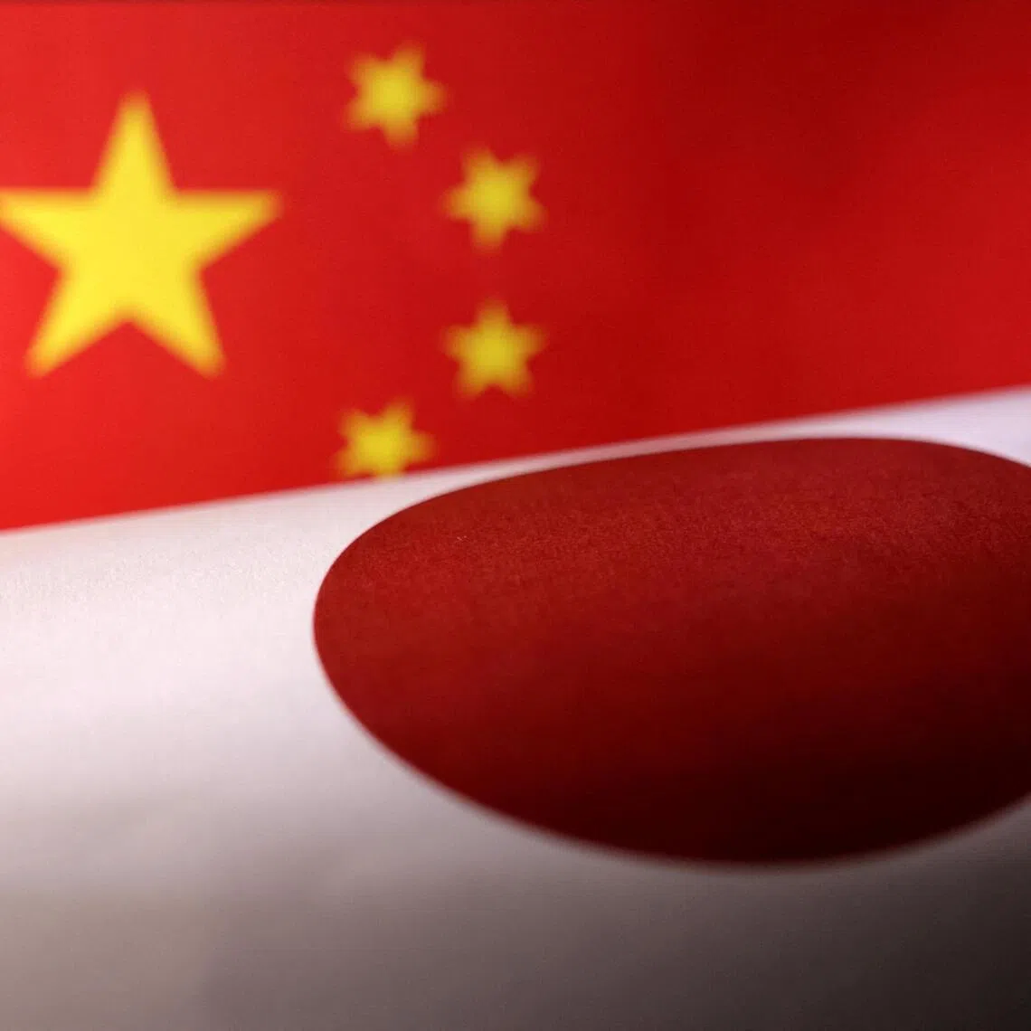 FILE PHOTO: Printed Chinese and Japanese flags are seen in this illustration, July 21, 2022. REUTERS/Dado Ruvic/Illustration/File Photo