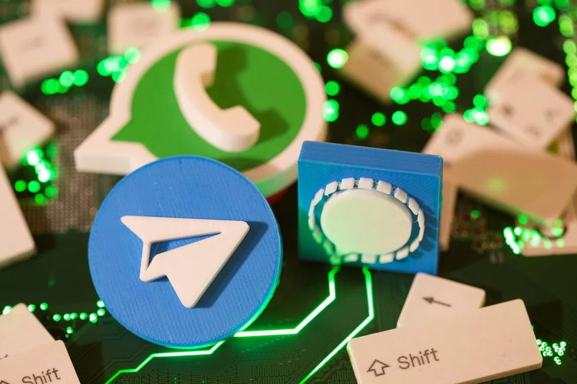 3D printed Telegram, Signal and WhatsApp logos and keyboard buttons are placed on a computer motherboard in this illustration taken January 21, 2021. REUTERS/Dado Ruvic/Illustration