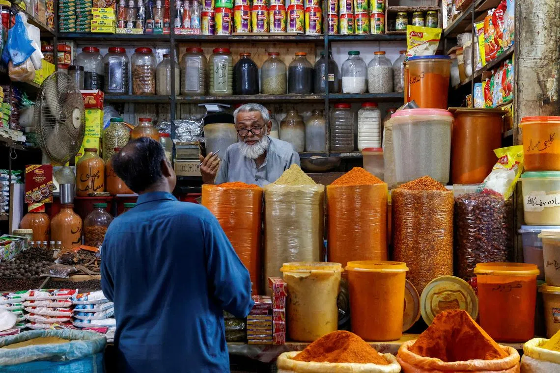 A shopkeeper speaks with a customer while selling spices at a market in Karachi, Pakistan June 11, 2024. REUTERS/Akhtar Soomro/File Photo