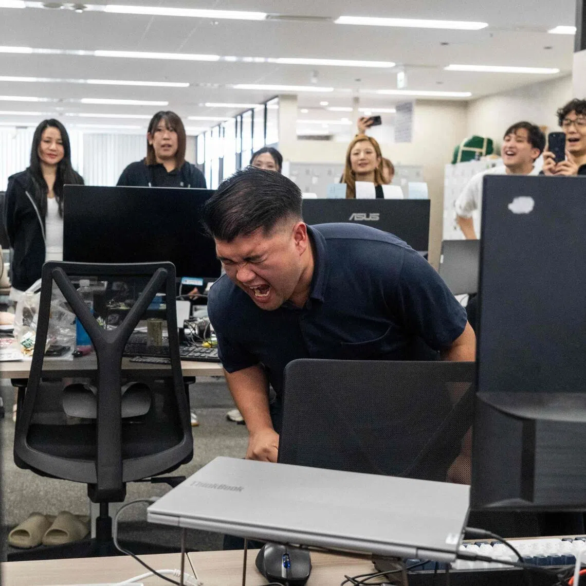An employee leads staff in a morning chant of work targets during a daily meeting, part of routine corporate practices aimed at boosting productivity, in Tokyo on June 1.