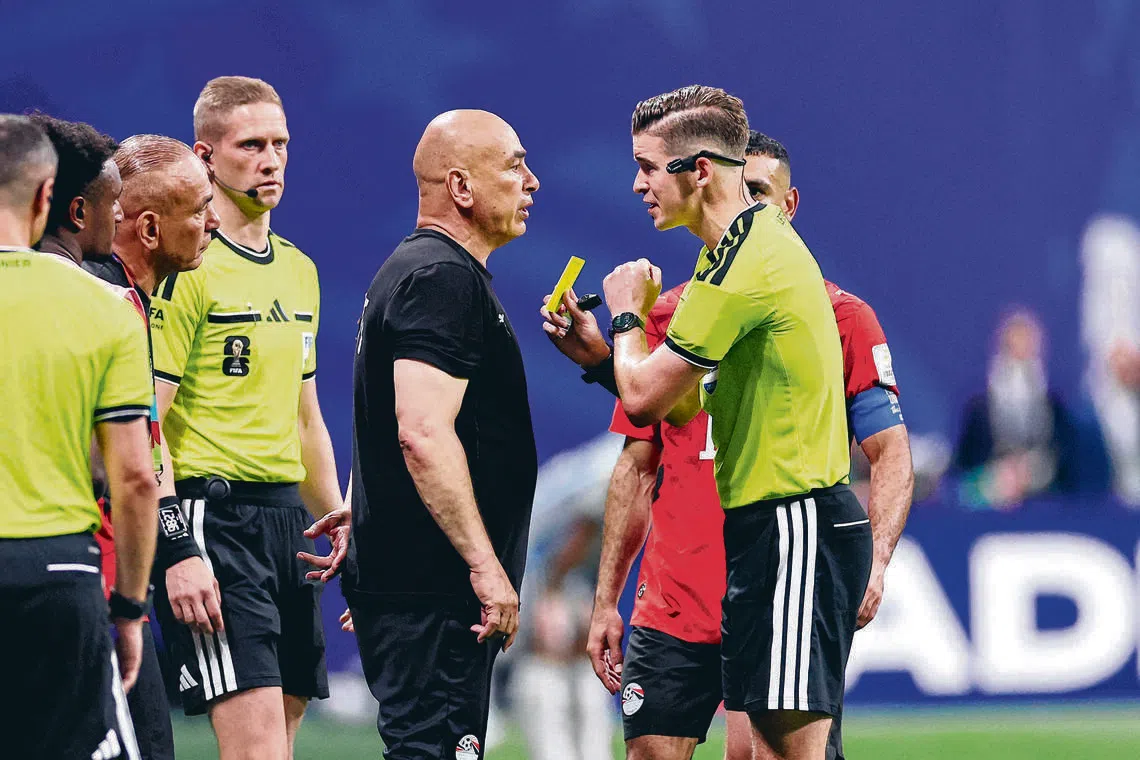 Referee Francois Letexier showing a yellow card to Egypt coach Hossam Hassan in their round of 16 match against Argentina on July 7.
