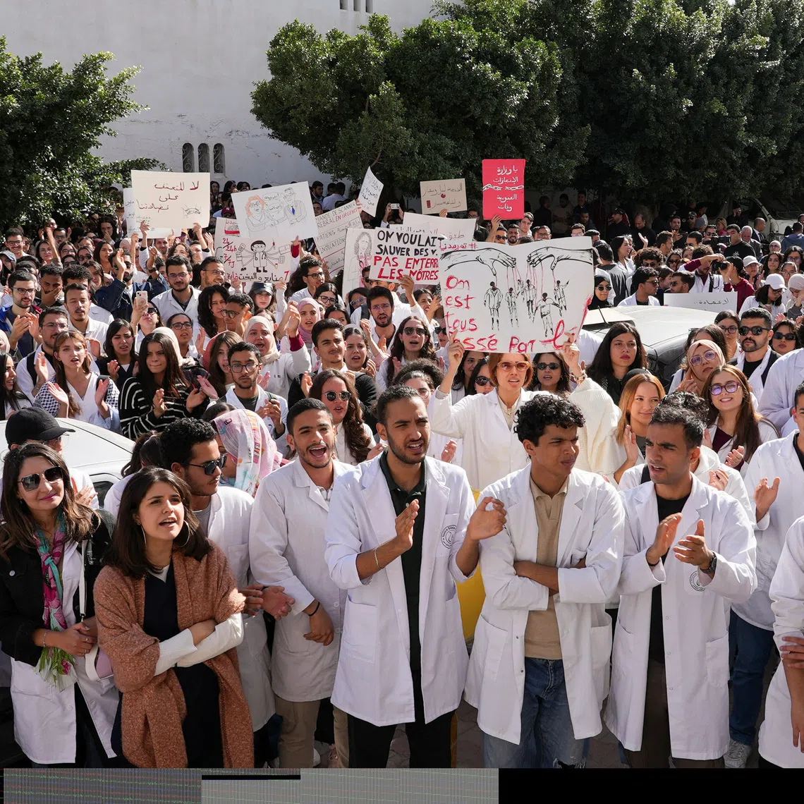 Young doctors gather and hold signs during a protest as thousands went on strike across Tunisia on Wednesday, demanding higher pay and warning of an impending collapse of the health system, part of a broader wave of social unrest convulsing the country, in Tunis, Tunisia, November 19, 2025. REUTERS/Jihed Abidellaoui