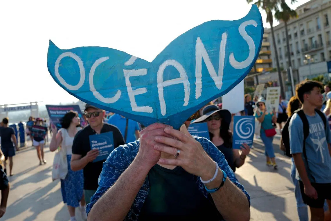 A protester takes part in the Blue March (Marche Bleue) on the Promenade des Anglais ahead of the United Nations Ocean Conference (Unoc 3), in the French riviera city of Nice, south-eastern France on June 7, 2025. The third edition of the United Nations Ocean Conference (Unoc 3) opens on June 9, 2025, in Nice, where many hope to see money and other concrete actions to protect marine life in polluted, overheated and overfished oceans. (Photo by Valery HACHE / AFP)
