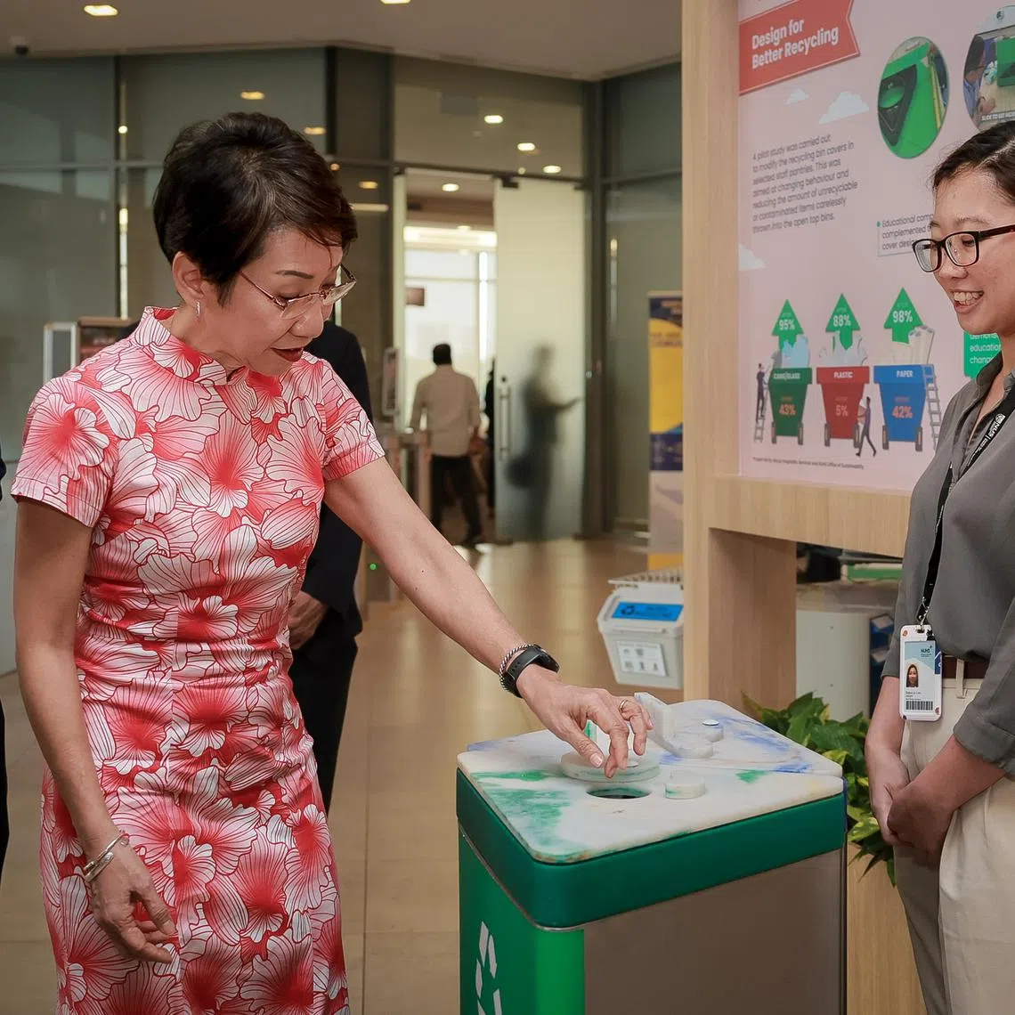 Minister for Sustainability and the Environment Grace Fu (centre), with NUH chief operating officer Jeremy Lee (left), trying out the Sort-at-Source initiative on June 11.