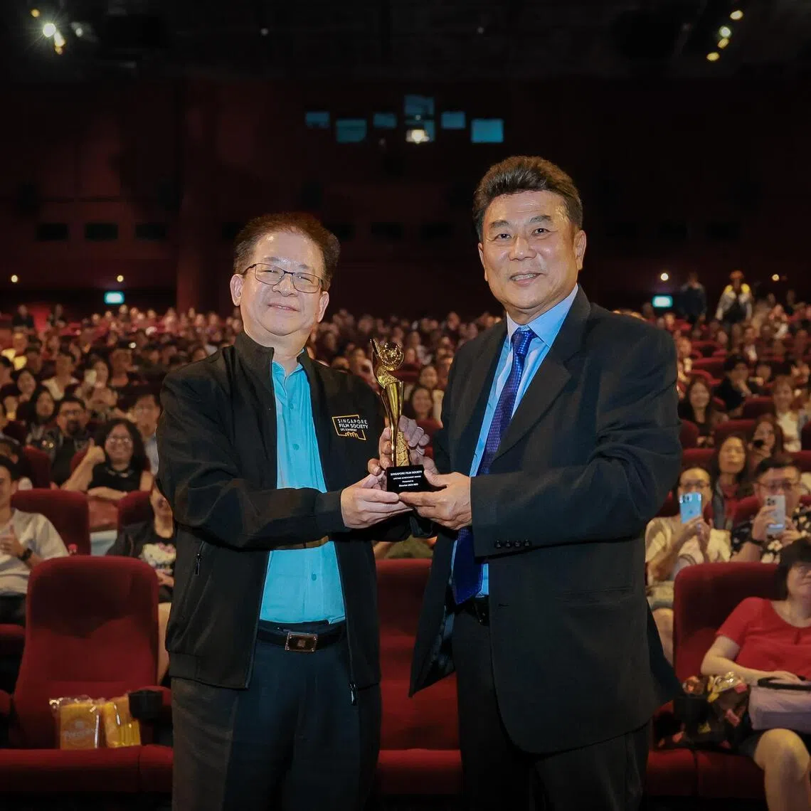 Singapore Film Society (SFS) chairman Kenneth Tan (left) presenting the Lifetime Achievement Award to Singaporean director Jack Neo (right) at Golden Village VivoCity on Jan 2, 2026.