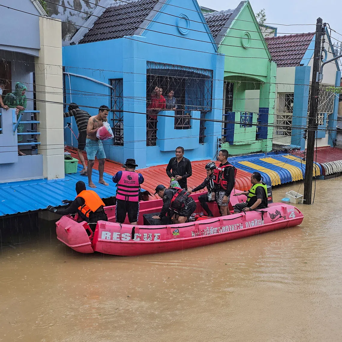 Members of rescue teams distribute supplies to stranded people in a flooded area in Hat Yai district, which has been affected by heavy rainfall that has hit 10 provinces in southern Thailand and killed several people, in Songkhla province, Thailand, November 24, 2025. REUTERS/Sithichai Chootochana