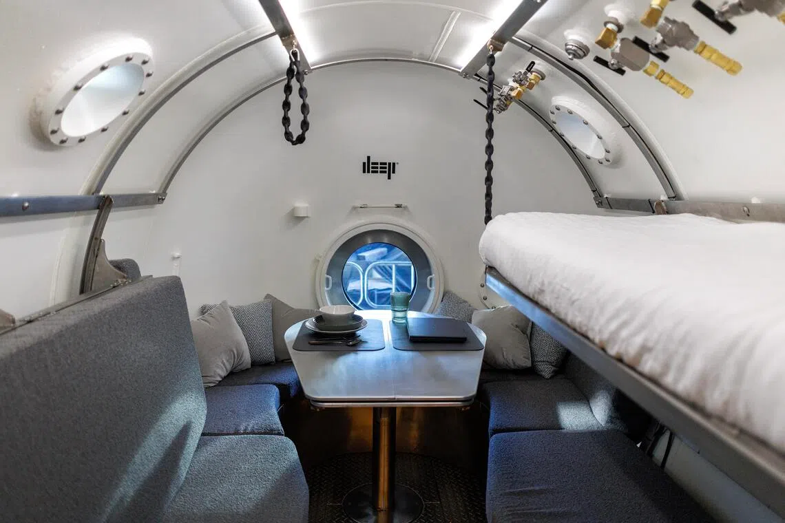 An interior view of the bedroom of the Vanguard subsea human habitat displayed in a warehouse.