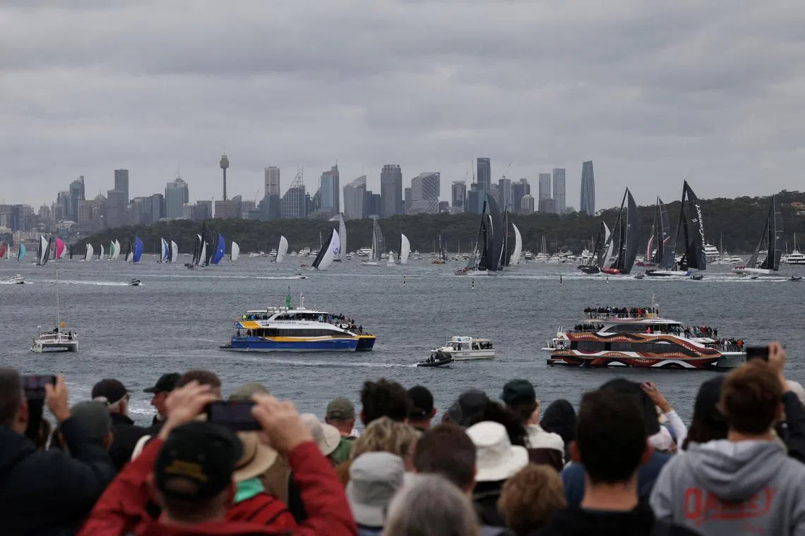 People watch as yachts race out of Sydney Harbour during the start of the 80th edition of The Rolex Sydney Hobart Yacht Race on Boxing Day in Sydney, Australia December 26, 2025. REUTERS/Hollie Adams