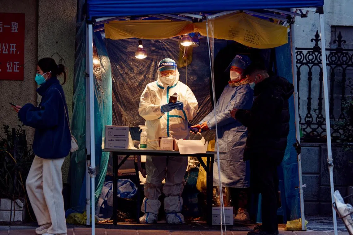 People take a Covid-19 PCR test in a street testing booth, in Shanghai, China, 14 December 2022.