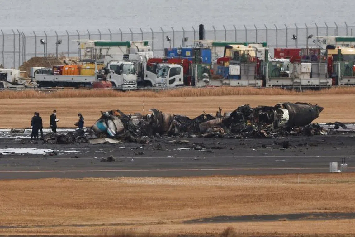 Officials investigate a burnt Japan Coast Guard aircraft after a collision with Japan Airlines' (JAL) Airbus A350 plane at Haneda International Airport in Tokyo, Japan January 3, 2024.  REUTERS/Issei Kato