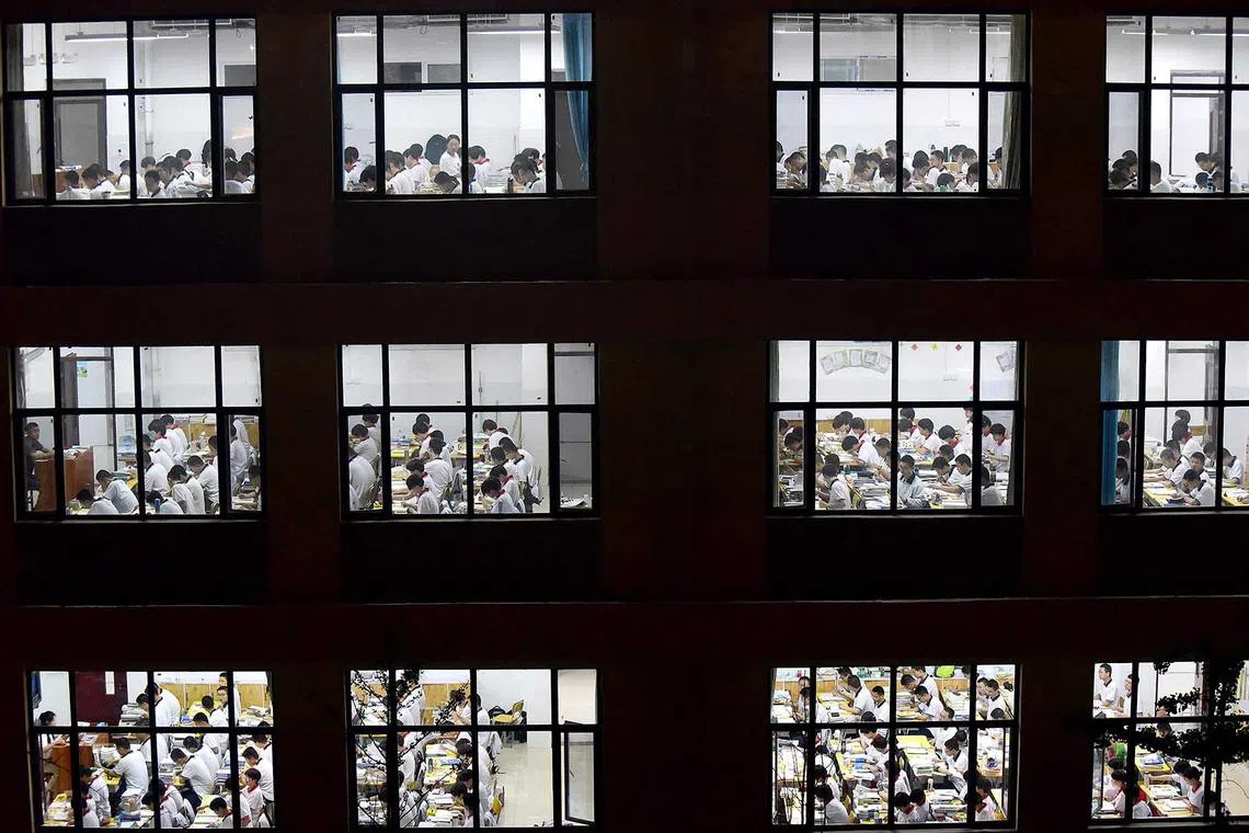 TOPSHOT - This photo taken on May 17, 2023 High school students going through exam papers, ahead of the National College Entrance Examination (NCEE) in Handan, China's northern Hebei province, May 17. 