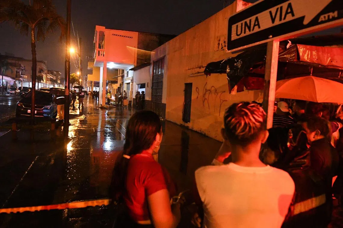 Ecuadorian police officers inspect a workshop after a multiple murder that left 10 dead in downtown Guayaquil.