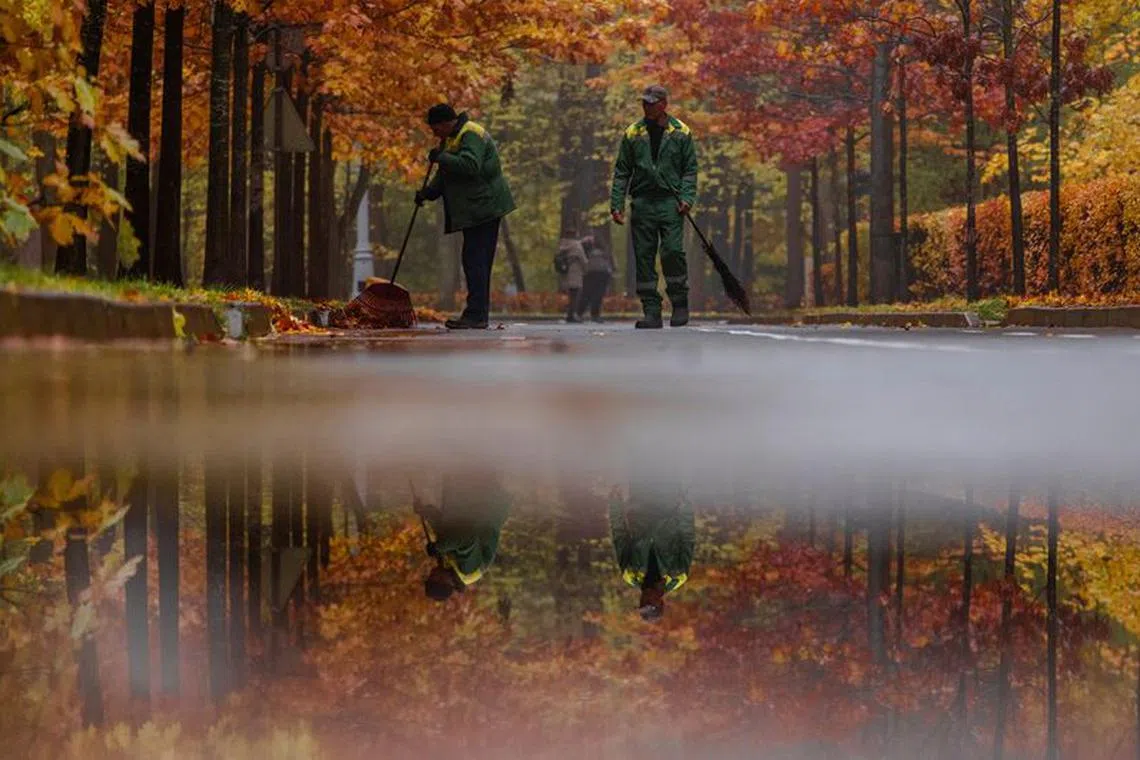 Communal workers sweep fallen leaves in a park in Moscow, Russia October 23, 2023. REUTERS/Maxim Shemetov