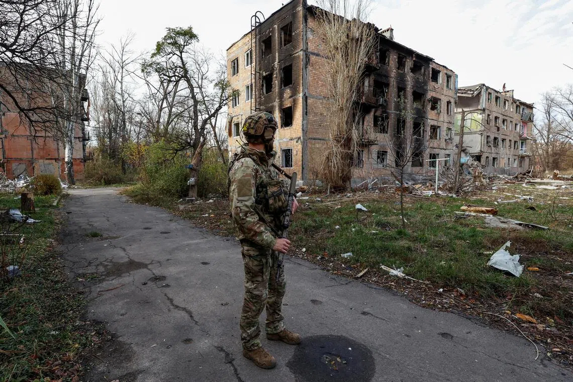 A Ukrainian serviceman stands near residential buildings heavily damaged by Russian strikes, in the front-line town of Avdiivka, in November 2023.