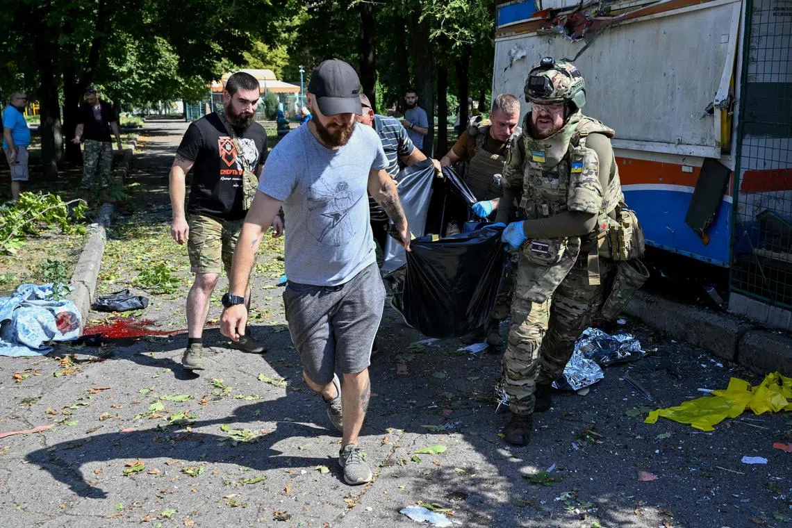 People helping Ukrainian police officers to carry a civilian's body into an ambulance, following Russian shelling in Kostiantynivka, in Ukraine's Donetsk region, on Aug 24.